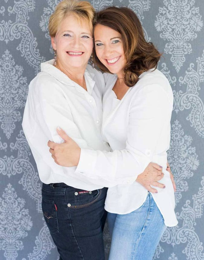Foto von 2 Frauen die sich umarmen und lächeln