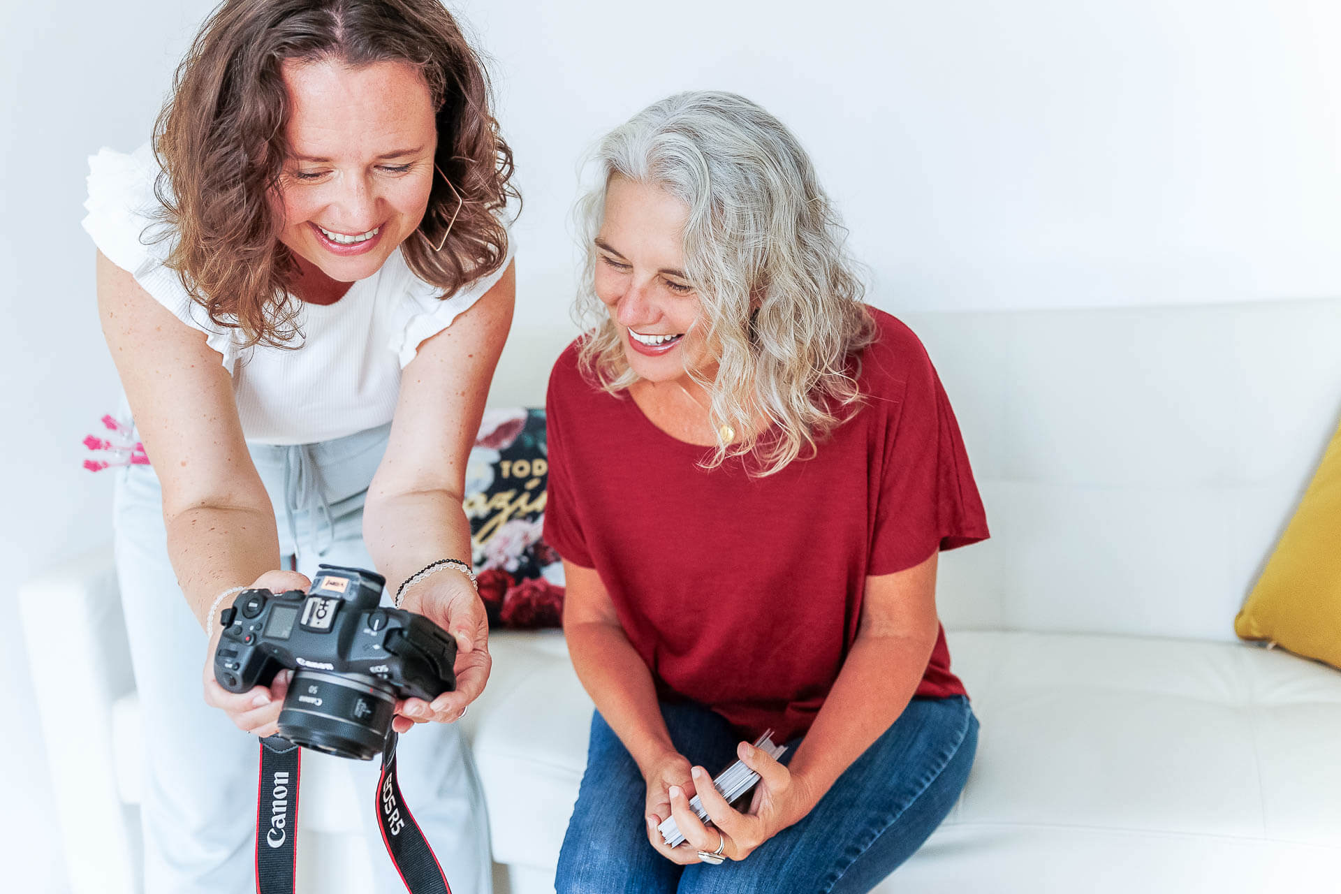Fotografin im Fotostudio fotografiert eine Frau, die in einer Meditationspose sitzt.