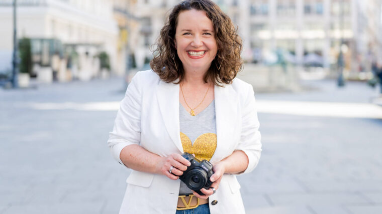 Fotografin in weissem Blazer mit Kamera in Wien