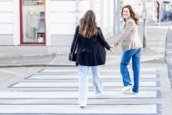 Portraitfoto von 2 Frauen die über die Strasse laufen und lachen