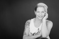 Kreatives Portraitfoto einer Frau mit kurzen Haaren und einem beeindruckenden Tattoo, das Selbstvertrauen ausstrahlt.
