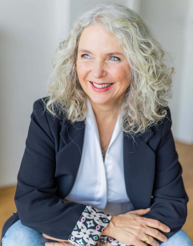 Professionelles Foto einer Frau die lachend aus dem Fenster sieht